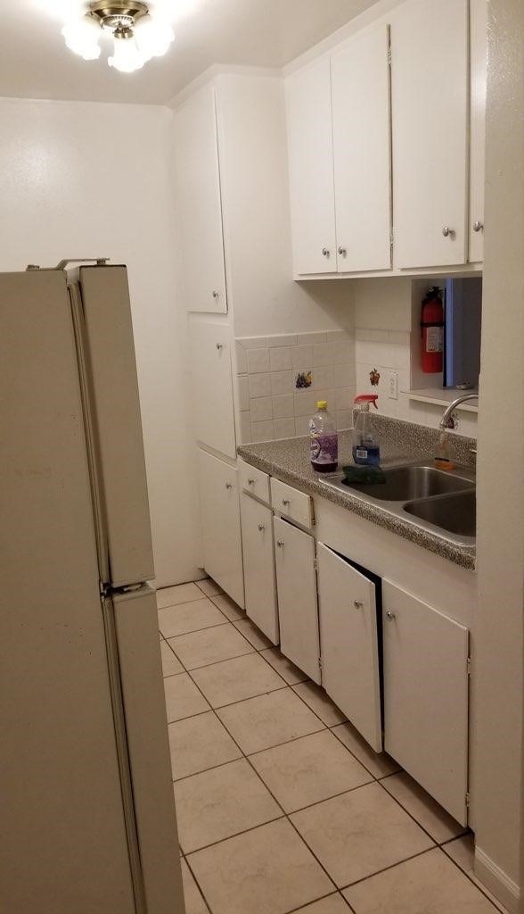 kitchen with white cabinetry, sink, white fridge, decorative backsplash, and light tile patterned flooring