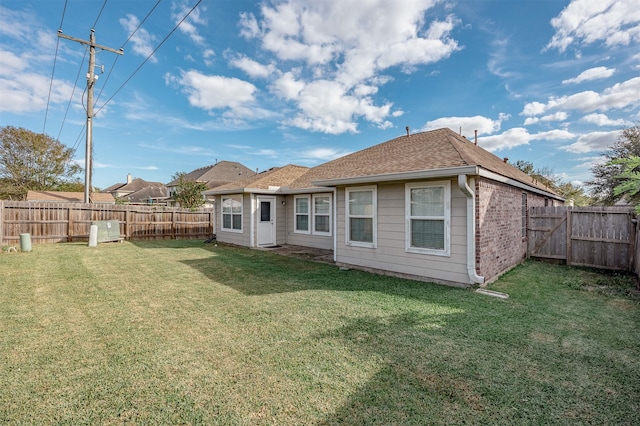 rear view of property featuring a lawn