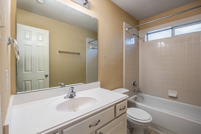 full bathroom featuring tiled shower / bath combo, toilet, a textured ceiling, and vanity