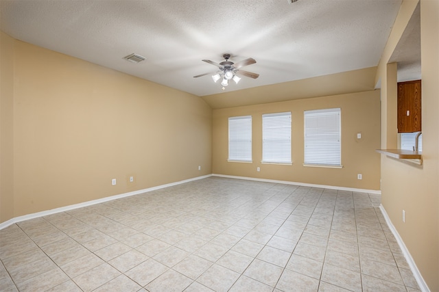 unfurnished room featuring a textured ceiling, ceiling fan, and light tile patterned flooring