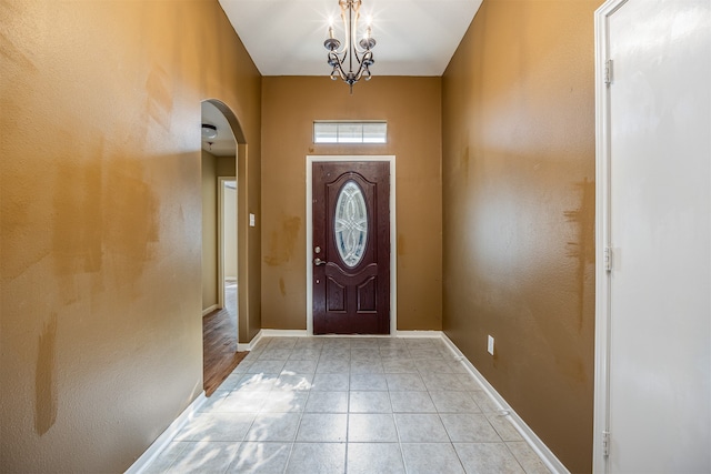 entryway with light tile patterned floors and a chandelier