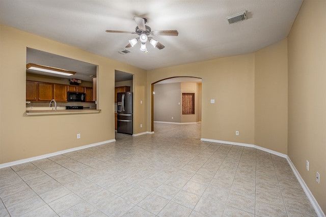 unfurnished living room with ceiling fan and sink