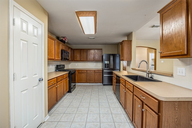 kitchen featuring light tile patterned floors, sink, backsplash, and black appliances