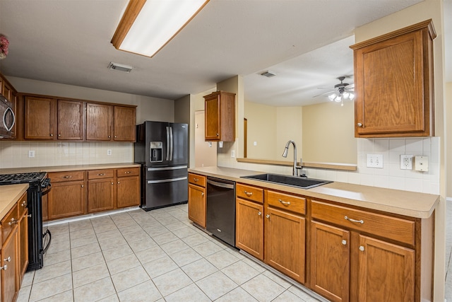 kitchen featuring tasteful backsplash, ceiling fan, sink, black appliances, and light tile patterned floors