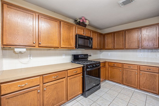 kitchen with black appliances, light tile patterned floors, and tasteful backsplash