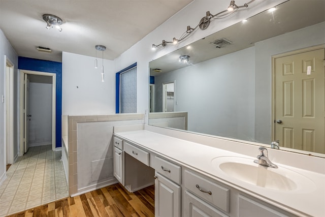 bathroom featuring a bath, hardwood / wood-style floors, and vanity