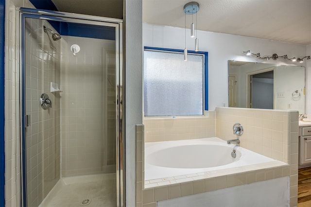 bathroom with hardwood / wood-style floors, vanity, a textured ceiling, and plus walk in shower