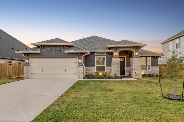 prairie-style home featuring a garage and a yard