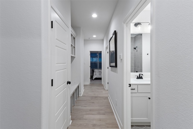 hall featuring light hardwood / wood-style flooring and sink