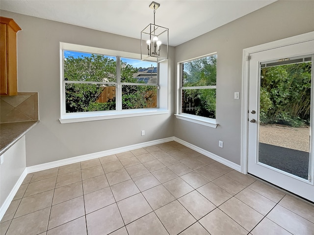 unfurnished dining area featuring light tile patterned flooring and a chandelier