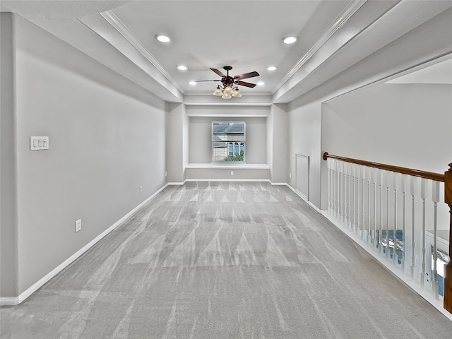 spare room with light carpet, a tray ceiling, and crown molding