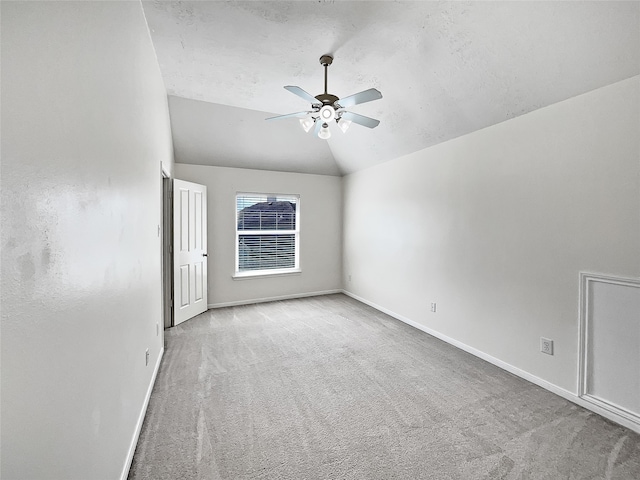 unfurnished room with ceiling fan, lofted ceiling, and light carpet