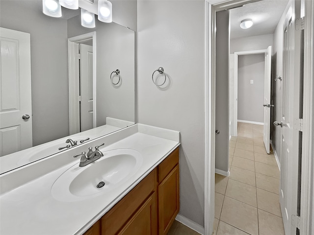 bathroom featuring tile patterned flooring, vanity, and a textured ceiling