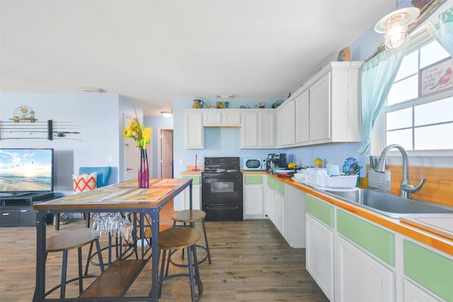 kitchen featuring electric range, dark hardwood / wood-style flooring, white cabinets, and sink