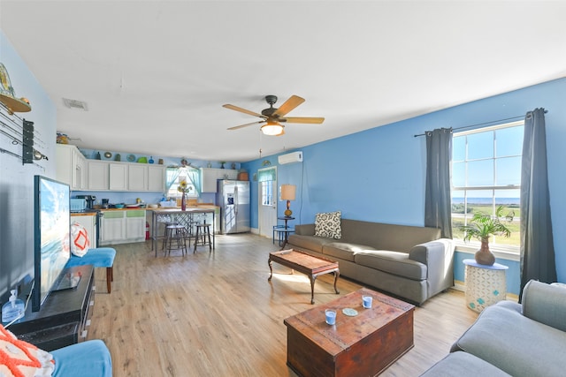 living room with ceiling fan and light hardwood / wood-style flooring