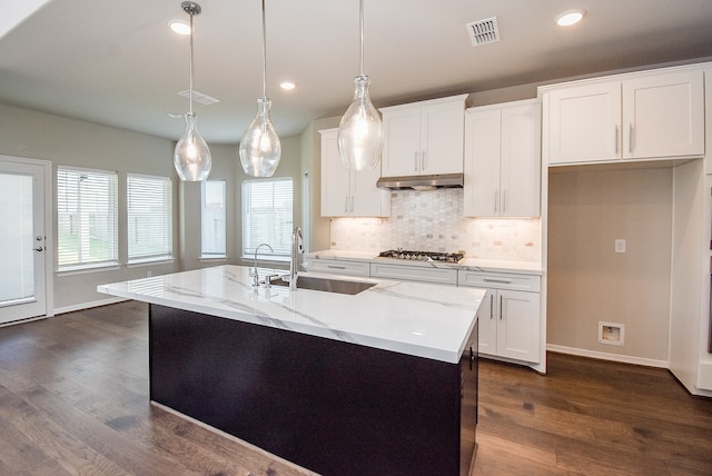 kitchen with a center island with sink, decorative light fixtures, white cabinets, and sink