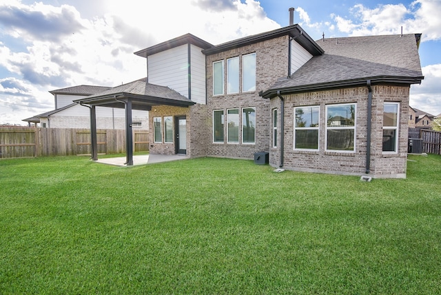 back of house with central AC unit, a yard, and a patio