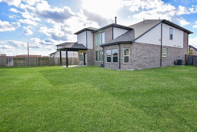 back of house featuring a lawn and central air condition unit