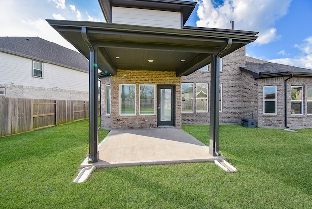 back of property with a lawn, a patio area, and central AC