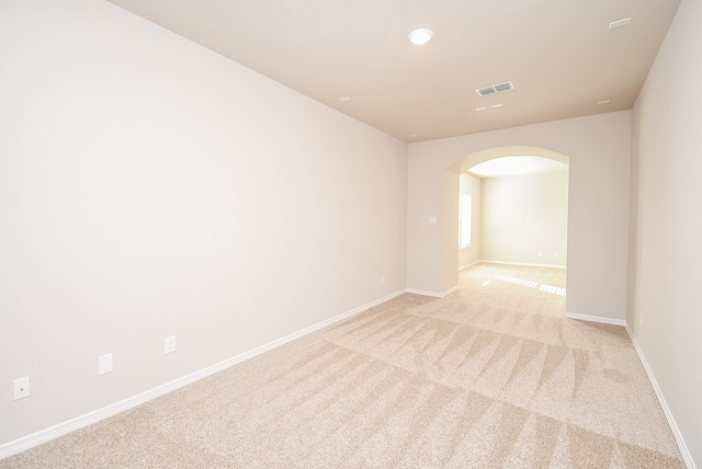 unfurnished room featuring light carpet