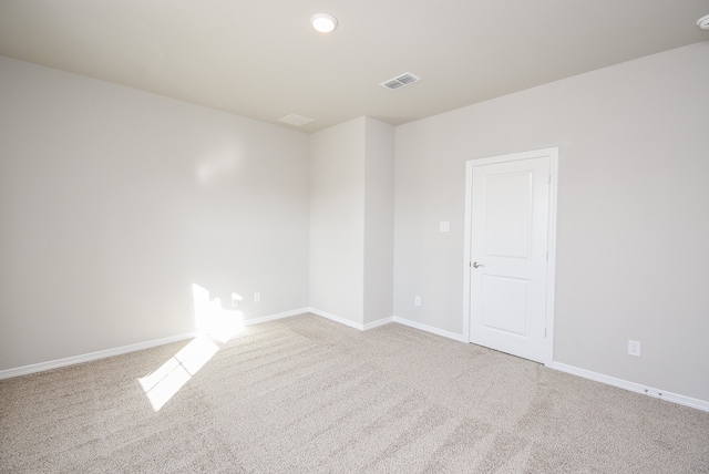 spare room featuring light carpet