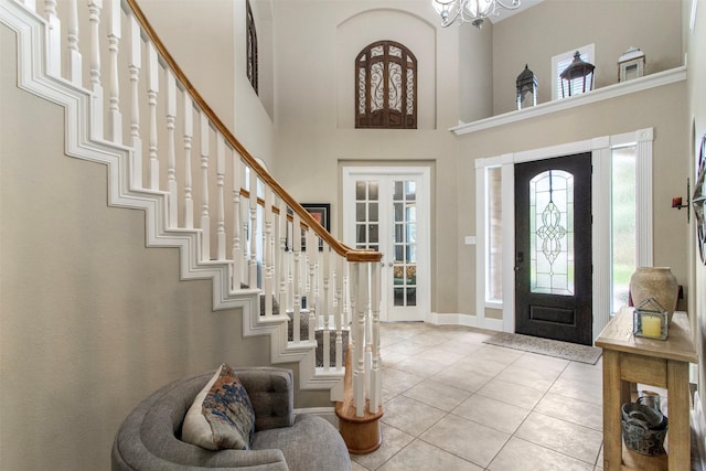 foyer featuring a high ceiling, an inviting chandelier, and light tile patterned floors