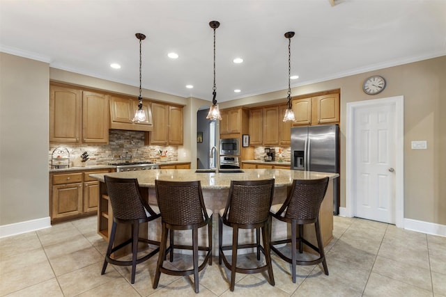 kitchen with stainless steel appliances, sink, tasteful backsplash, light stone countertops, and a center island with sink