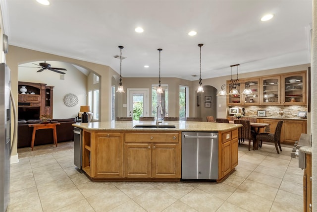 kitchen featuring sink, pendant lighting, light stone countertops, a kitchen island with sink, and appliances with stainless steel finishes