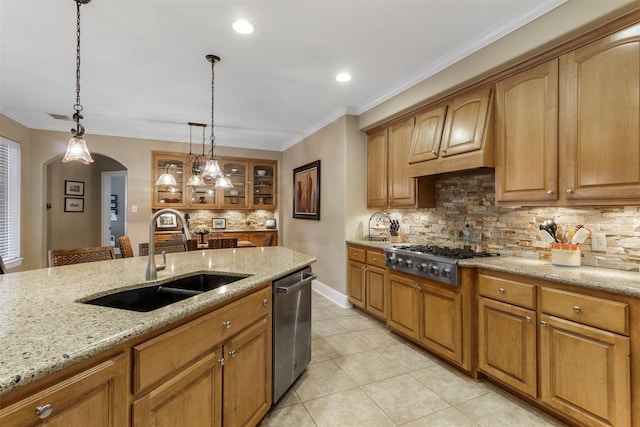 kitchen featuring stainless steel appliances, light stone counters, sink, decorative light fixtures, and backsplash