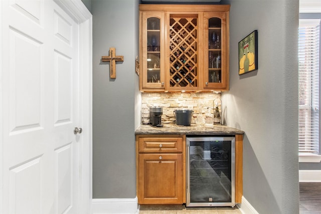 bar featuring decorative backsplash, stone countertops, and wine cooler