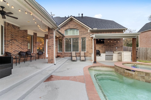 view of pool featuring an outdoor kitchen, an in ground hot tub, ceiling fan, exterior bar, and a patio