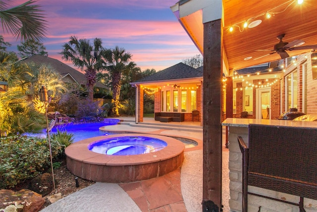 pool at dusk with ceiling fan, a patio, an in ground hot tub, and an outdoor living space