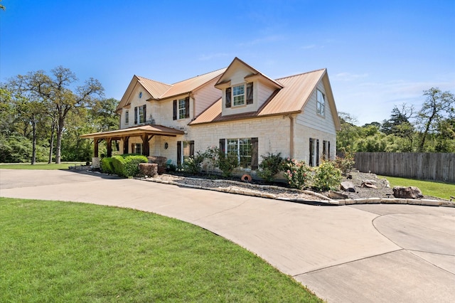 5960HIGHWAY 36 N, Bellville, TX 77418 - view of front of house with metal roof, stone siding, a front lawn, and fence