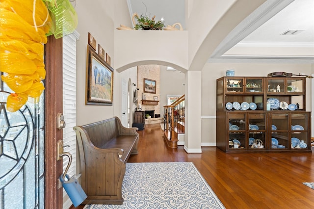5960HIGHWAY 36 N, Bellville, TX 77418 - foyer featuring wood finished floors, visible vents, arched walkways, crown molding, and a large fireplace