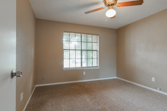 carpeted spare room with a textured ceiling and ceiling fan