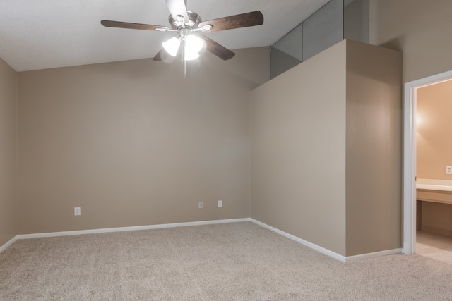 unfurnished room with ceiling fan, light colored carpet, and vaulted ceiling