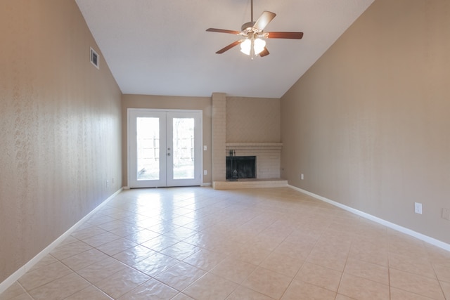 unfurnished living room featuring french doors, ceiling fan, light tile patterned floors, high vaulted ceiling, and a fireplace