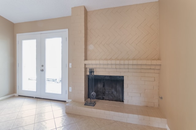 unfurnished living room with a fireplace, french doors, a textured ceiling, and light tile patterned flooring