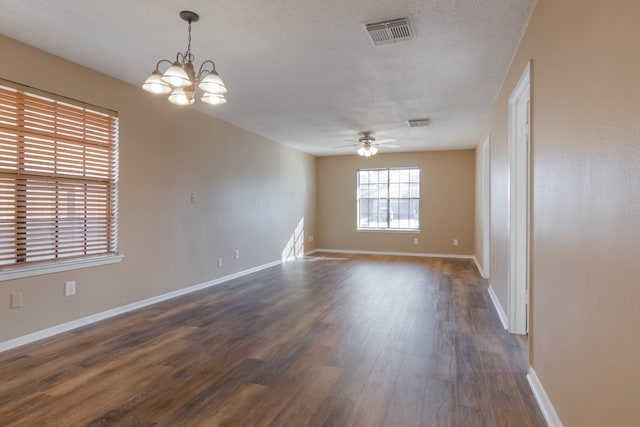 unfurnished room with ceiling fan with notable chandelier, dark hardwood / wood-style flooring, and a textured ceiling