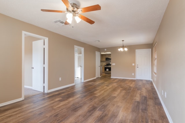 unfurnished living room featuring ceiling fan with notable chandelier, a textured ceiling, and dark wood-type flooring