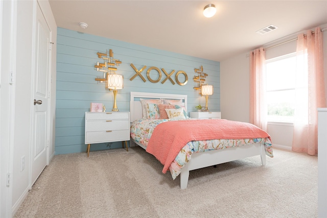 bedroom featuring wooden walls and carpet