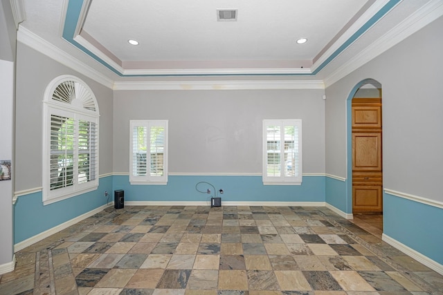 spare room featuring a raised ceiling and ornamental molding