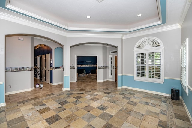 spare room featuring a tray ceiling, crown molding, and a textured ceiling