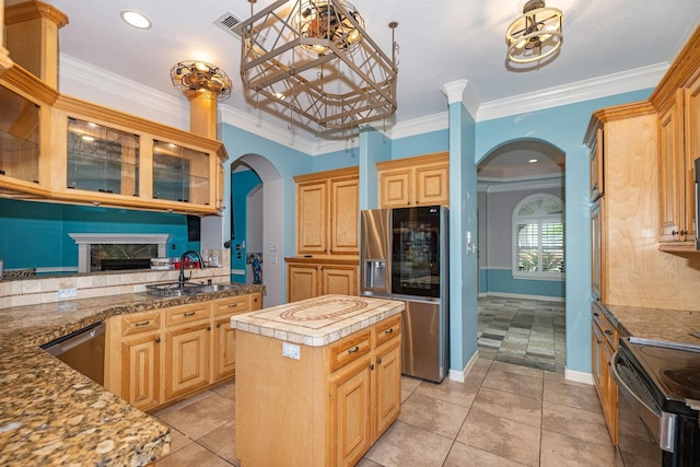 kitchen featuring a center island, light brown cabinets, stainless steel appliances, sink, and ornamental molding