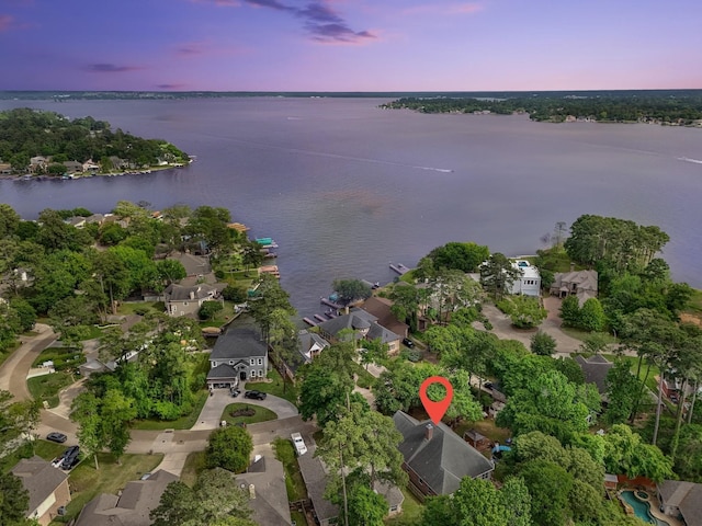 aerial view at dusk featuring a water view