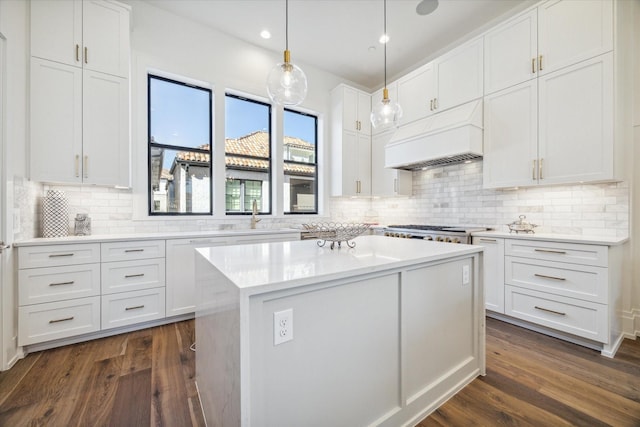 kitchen with a center island, white cabinets, and custom exhaust hood