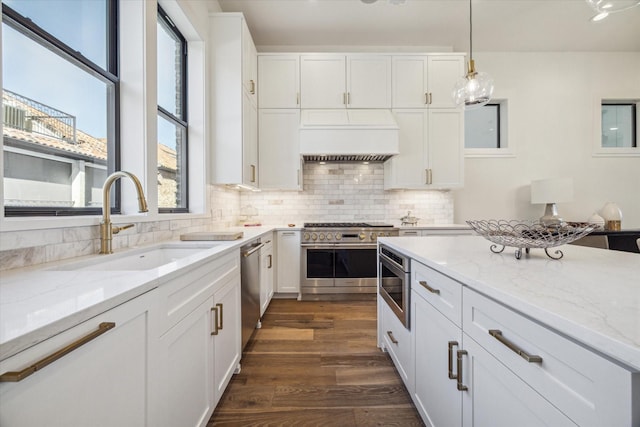 kitchen featuring white cabinetry, dark hardwood / wood-style flooring, decorative light fixtures, and appliances with stainless steel finishes