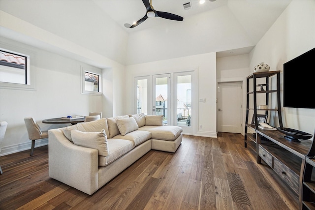 living room with dark hardwood / wood-style floors, ceiling fan, and high vaulted ceiling