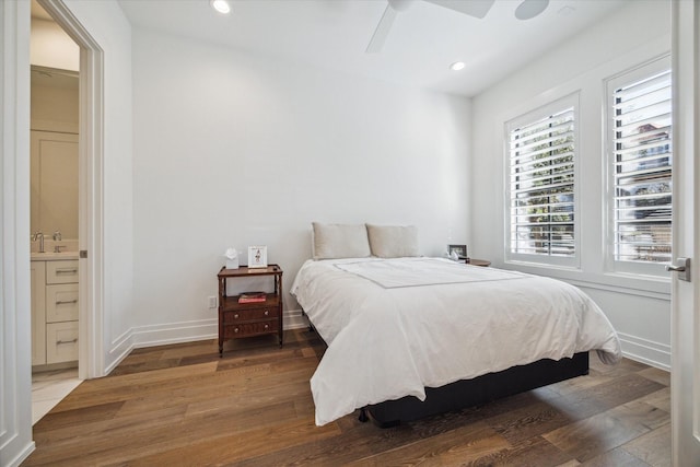 bedroom with connected bathroom, ceiling fan, dark wood-type flooring, and sink