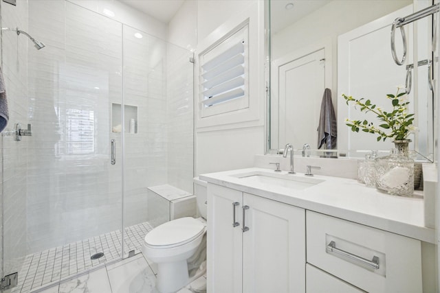 bathroom featuring vanity, toilet, and a shower with door